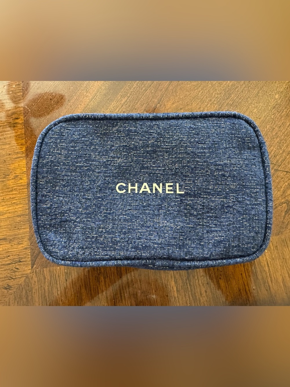 Chanel cosmetic bag with gold logo and zipper.